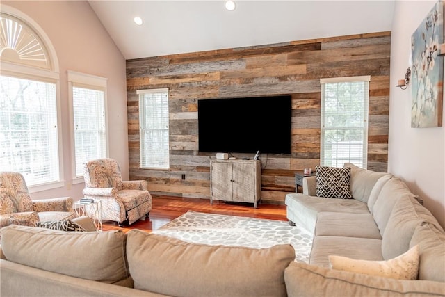 living room featuring wooden walls, vaulted ceiling, and hardwood / wood-style flooring