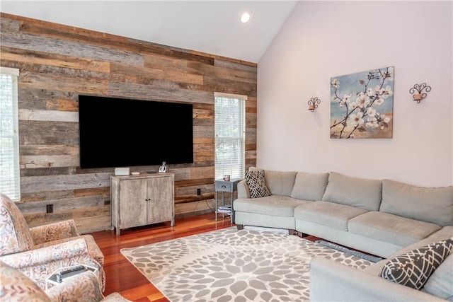 living room featuring lofted ceiling, wood walls, and hardwood / wood-style floors