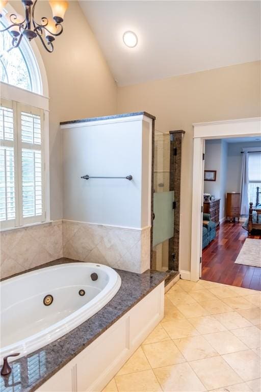 bathroom featuring lofted ceiling, a notable chandelier, tile patterned floors, and independent shower and bath