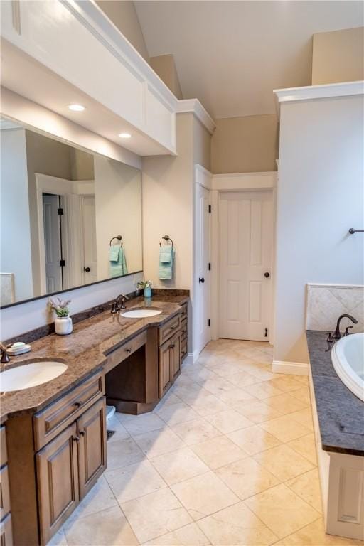 bathroom with tile patterned floors, vanity, and a bathing tub