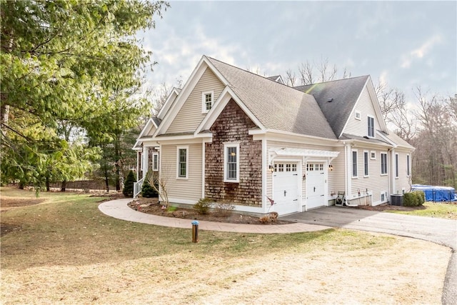 view of home's exterior with a lawn, cooling unit, and a garage