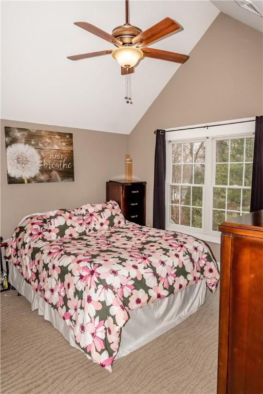 carpeted bedroom featuring lofted ceiling and ceiling fan