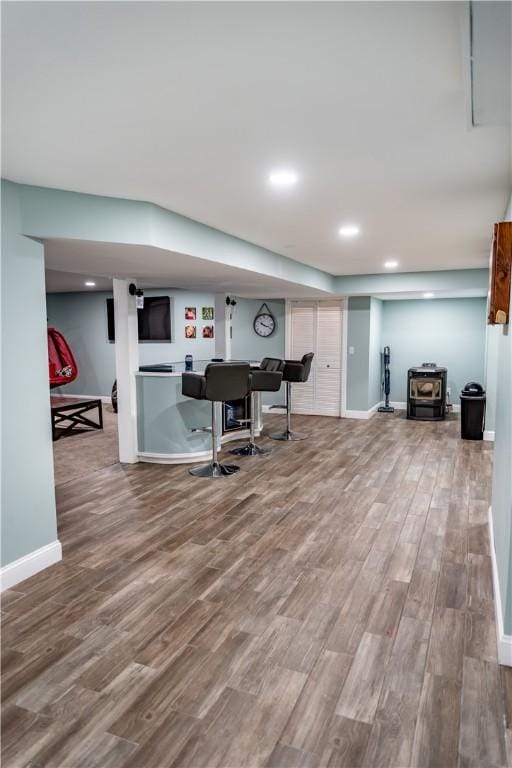 interior space with a wood stove and wood-type flooring