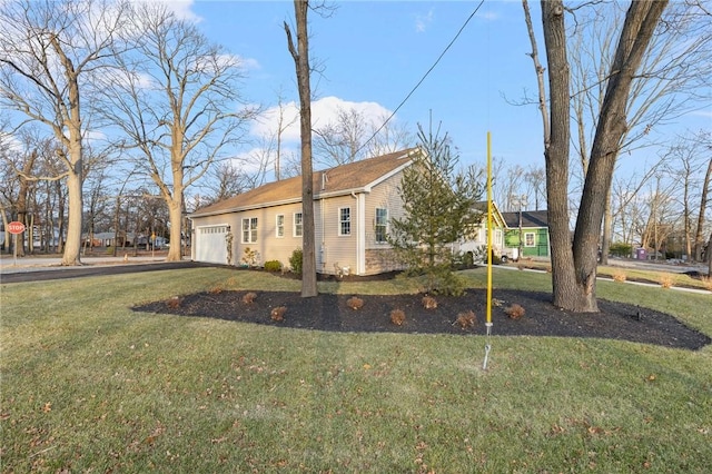 view of side of property with a garage and a lawn