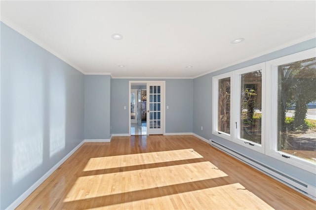 spare room with french doors, baseboard heating, crown molding, and light hardwood / wood-style flooring