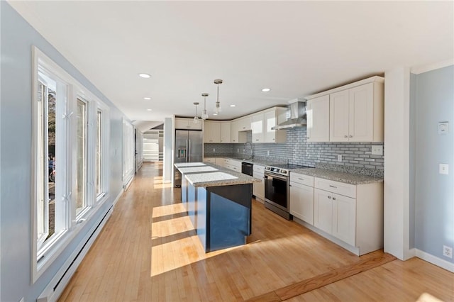 kitchen featuring stainless steel appliances, decorative light fixtures, a center island, a breakfast bar area, and wall chimney range hood