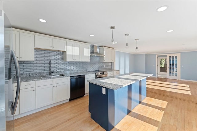 kitchen with light stone countertops, hanging light fixtures, stainless steel appliances, wall chimney range hood, and white cabinetry