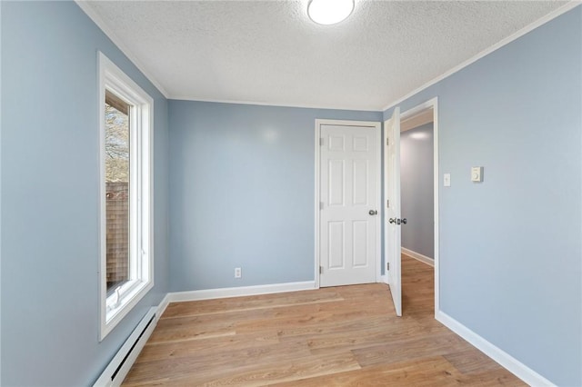 unfurnished room featuring a textured ceiling, ornamental molding, light hardwood / wood-style flooring, and a healthy amount of sunlight