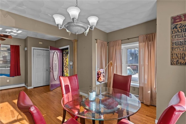 dining area featuring a chandelier, baseboard heating, and light wood-type flooring