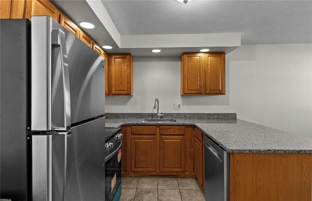 kitchen featuring light tile patterned floors, kitchen peninsula, appliances with stainless steel finishes, and sink