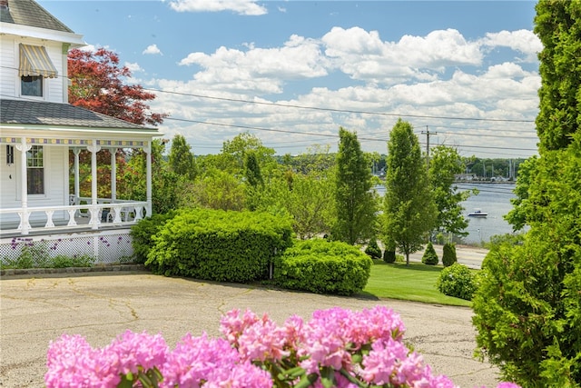 view of yard with a porch and a water view