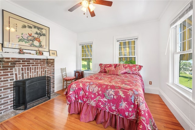 bedroom with crown molding, multiple windows, and wood finished floors