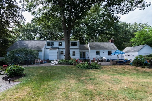 rear view of property with a yard and a patio