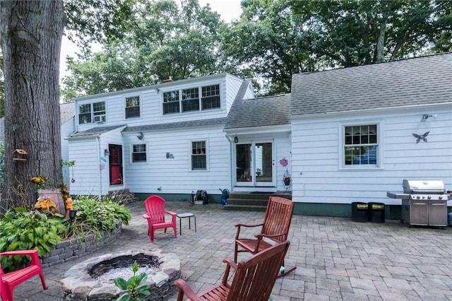 rear view of property featuring an outdoor fire pit and a patio