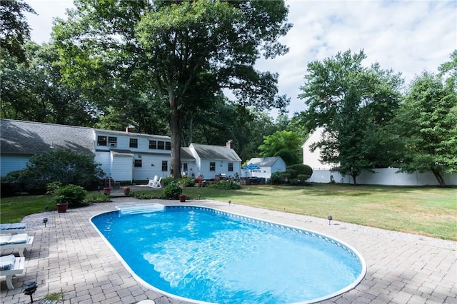 view of pool with an outdoor structure, a patio area, and a lawn