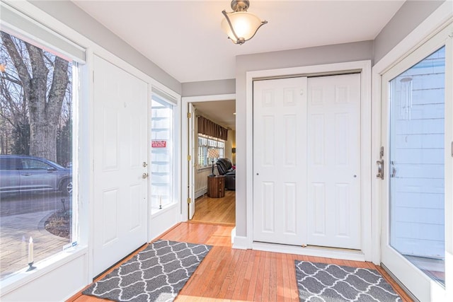 foyer entrance featuring wood-type flooring and a baseboard radiator