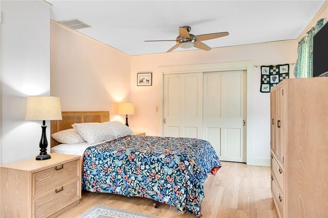 bedroom with ceiling fan, light hardwood / wood-style flooring, and a closet