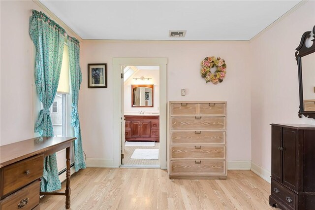 interior space with ensuite bathroom, light hardwood / wood-style floors, and sink