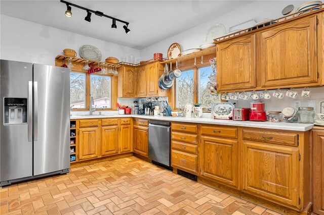 kitchen with sink, stainless steel appliances, a healthy amount of sunlight, and tasteful backsplash