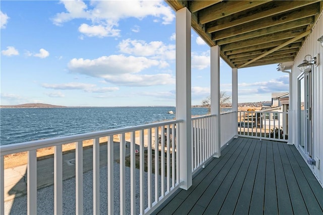 balcony with a water view and a view of the beach