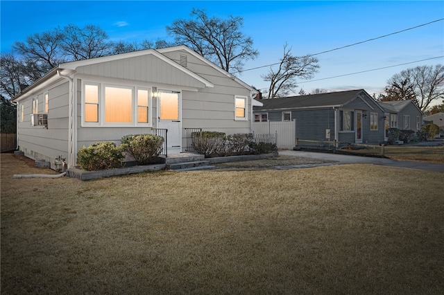 view of front of home featuring cooling unit and a front lawn