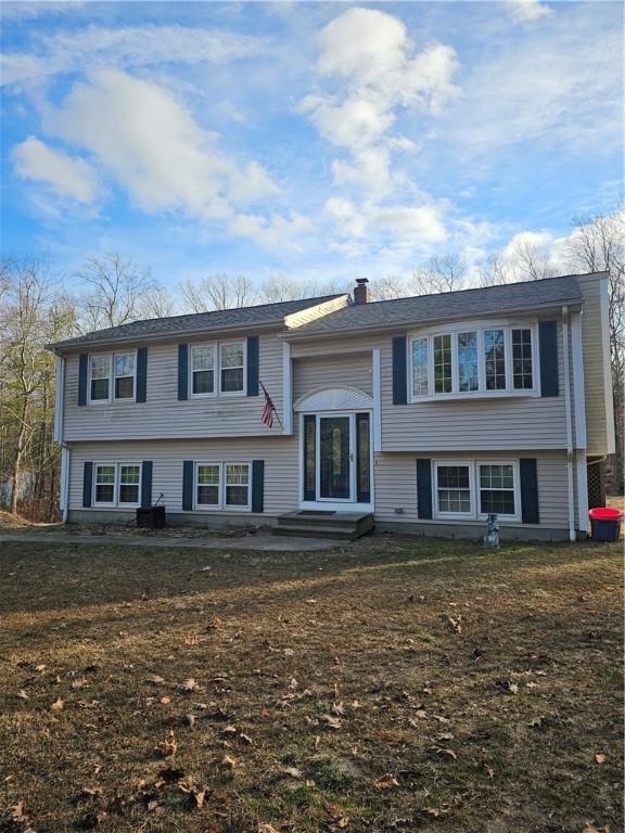 split foyer home featuring a front yard and a patio area