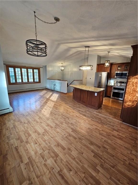 unfurnished living room featuring dark wood-type flooring, an inviting chandelier, and a baseboard heating unit