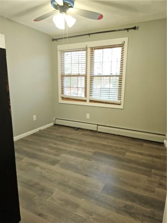 spare room with a baseboard heating unit, ceiling fan, and dark hardwood / wood-style floors