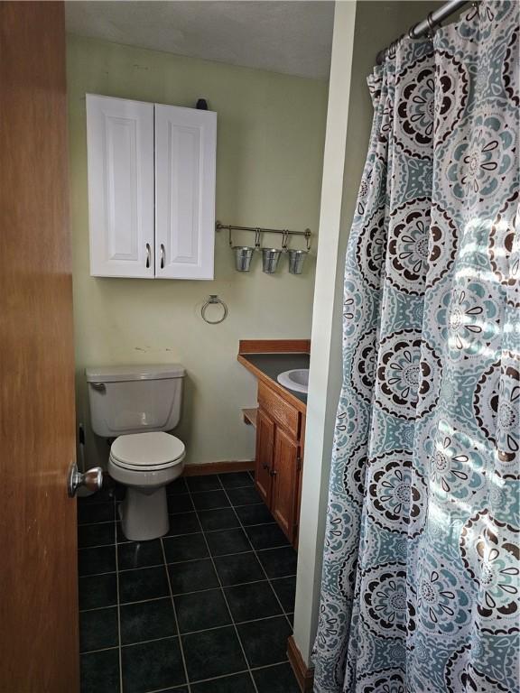 bathroom featuring tile patterned flooring, vanity, and toilet