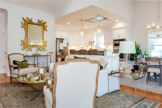 living room featuring light hardwood / wood-style floors, sink, and a chandelier