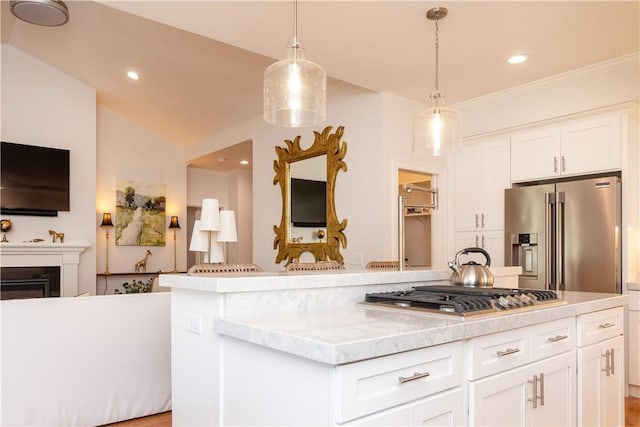 kitchen featuring stainless steel appliances, white cabinets, pendant lighting, and light stone counters