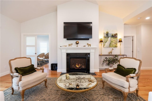 living area with vaulted ceiling and light hardwood / wood-style flooring