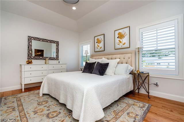 bedroom featuring lofted ceiling and light wood-type flooring