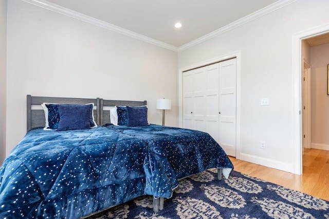 bedroom with hardwood / wood-style flooring, ornamental molding, and a closet