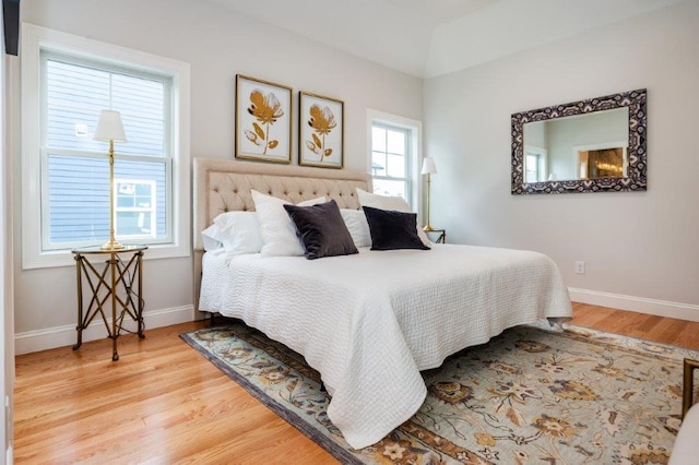 bedroom with multiple windows and hardwood / wood-style flooring