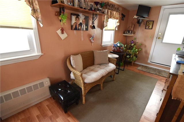 sitting room with light hardwood / wood-style floors, radiator, and a wealth of natural light