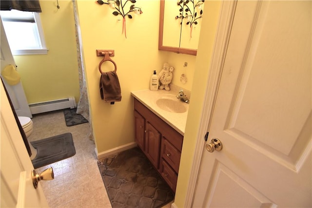 bathroom featuring toilet, vanity, and a baseboard heating unit