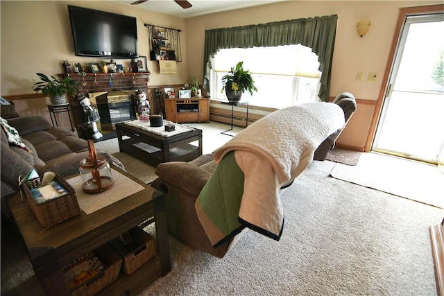 carpeted living room with ceiling fan, a healthy amount of sunlight, and a fireplace