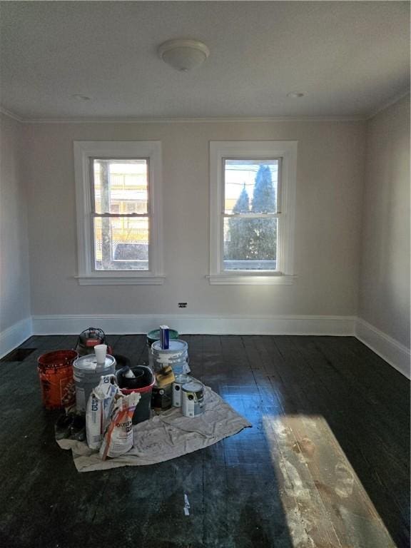 empty room with crown molding and dark wood-type flooring