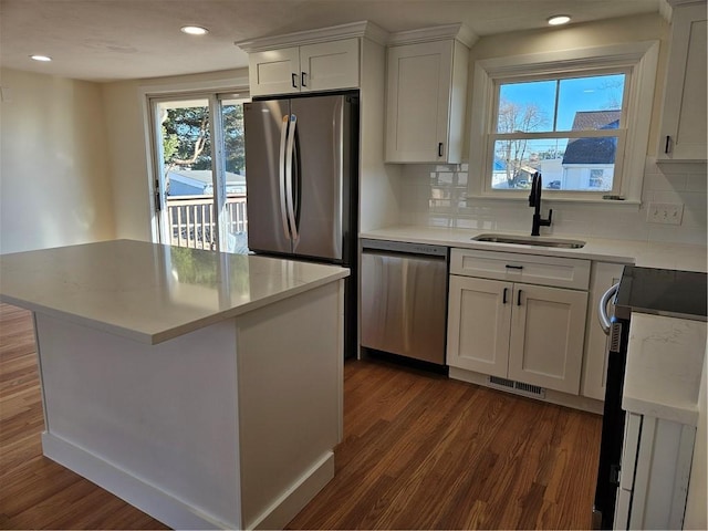 kitchen with sink, white cabinets, tasteful backsplash, dark hardwood / wood-style floors, and appliances with stainless steel finishes