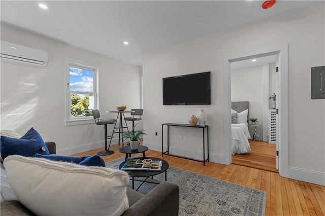 living room featuring wood-type flooring, electric panel, and an AC wall unit