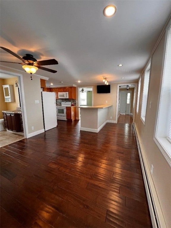 unfurnished living room featuring baseboard heating, dark hardwood / wood-style flooring, and ceiling fan