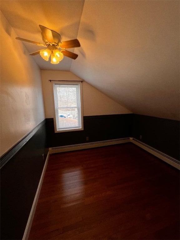 additional living space with ceiling fan, vaulted ceiling, and dark hardwood / wood-style flooring