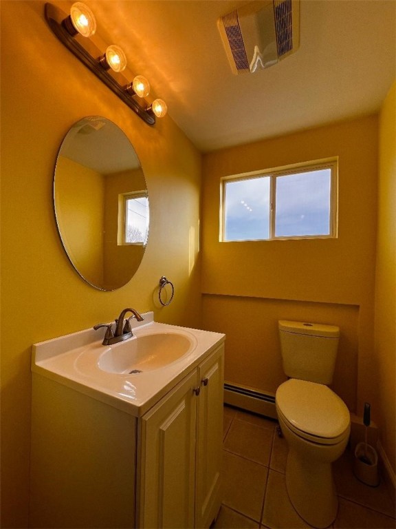 bathroom featuring toilet, vanity, baseboard heating, and tile patterned floors