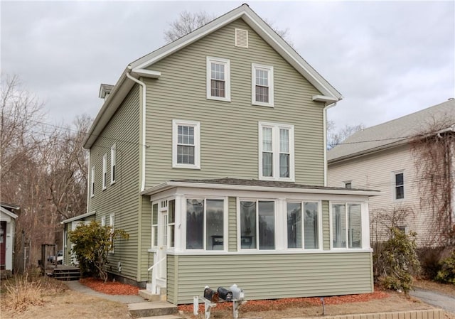 rear view of property with a sunroom