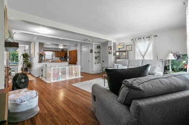 living room with ceiling fan, built in features, and light hardwood / wood-style floors