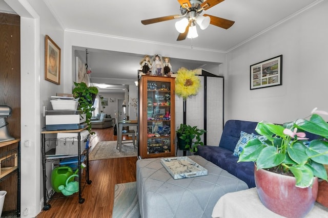 living room with hardwood / wood-style flooring, crown molding, and ceiling fan