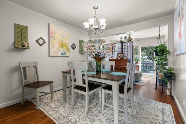 dining area featuring baseboards, ornamental molding, wood finished floors, and a notable chandelier