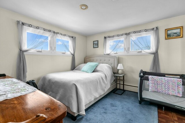 bedroom with a baseboard radiator and multiple windows