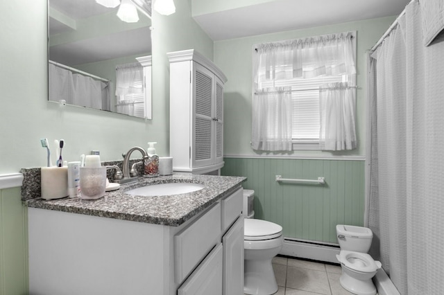 bathroom with tile patterned flooring, a baseboard heating unit, vanity, wooden walls, and toilet